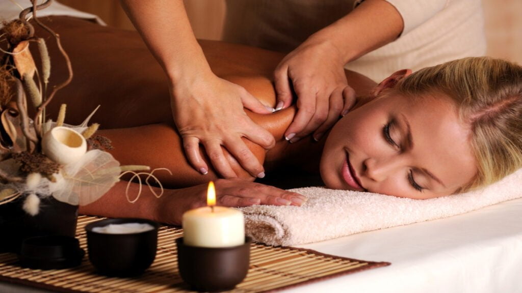 masseur doing massage on female shoulder in the beauty salon