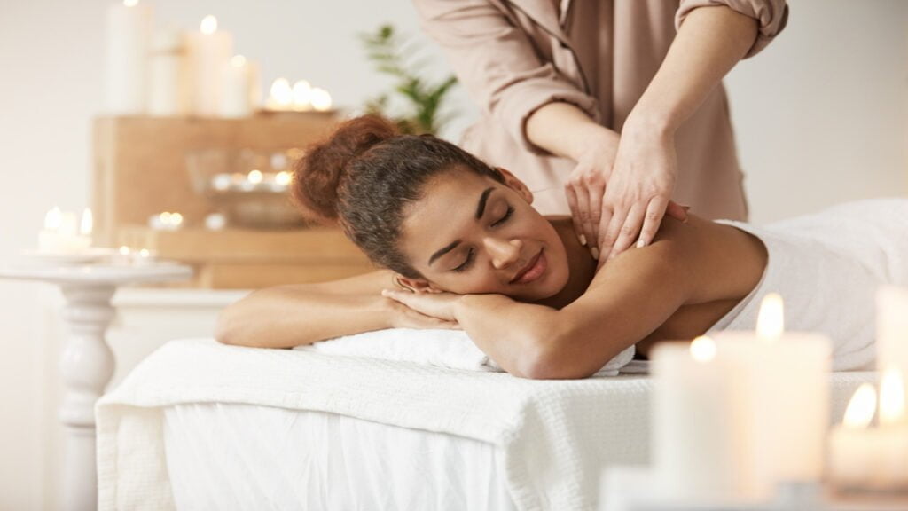 tender african woman smiling enjoying massage with closed eyes in spa resort 1