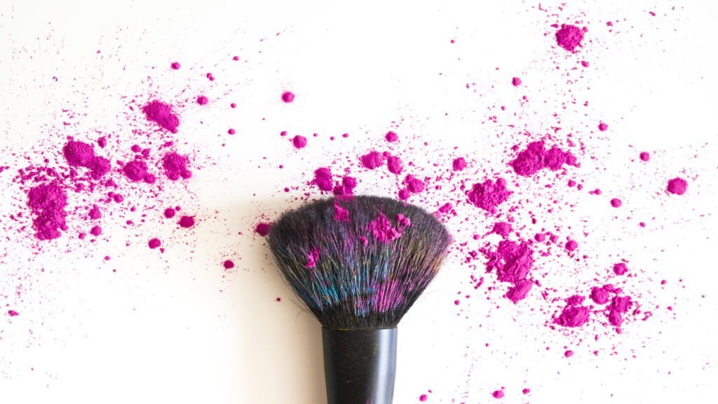 top view of make up brush and pink face powder